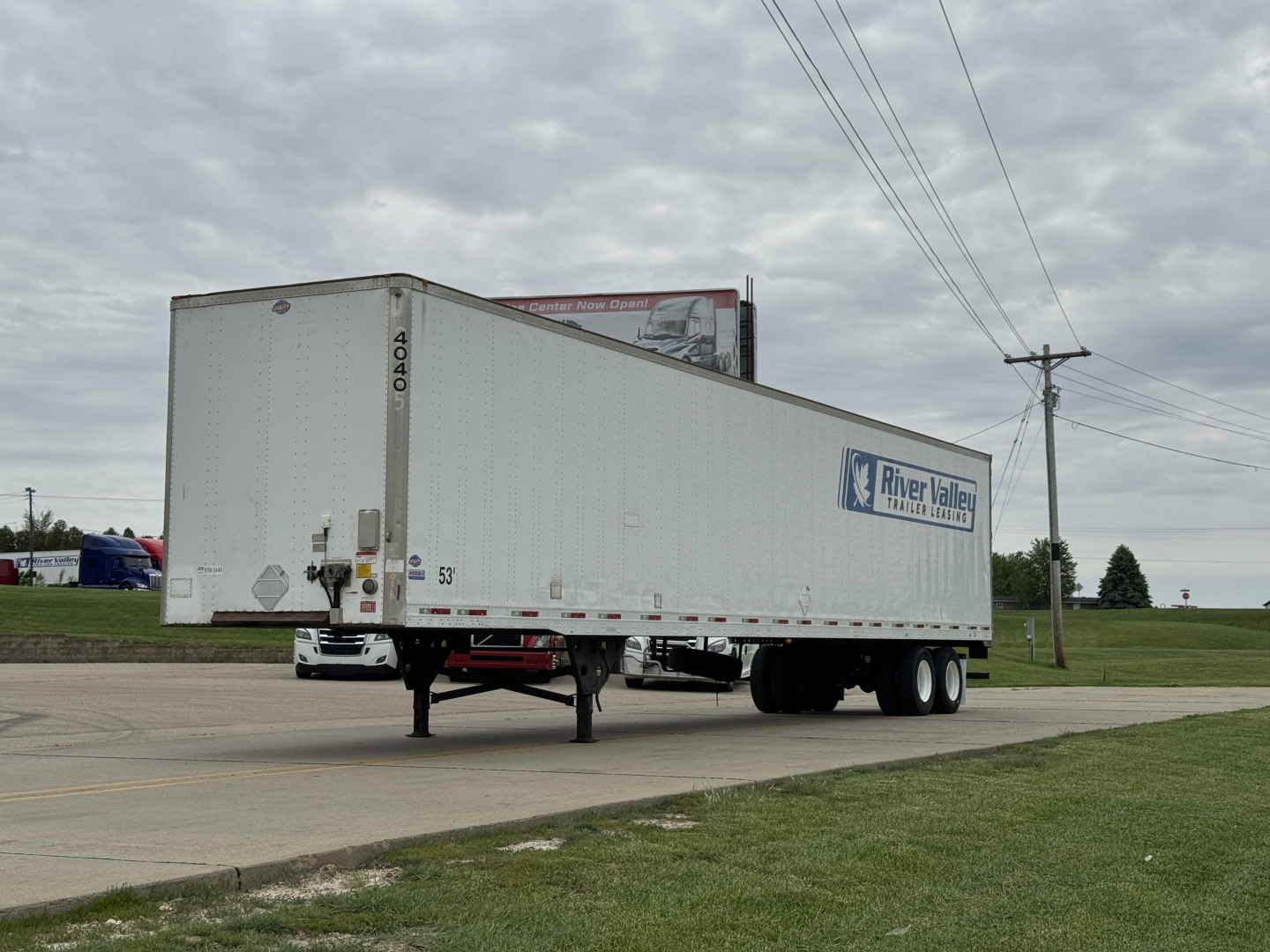 Utility 4000D-X trailer shown in side view with River Valley logo, parked on road, front landing gear visible, dual rear axles.