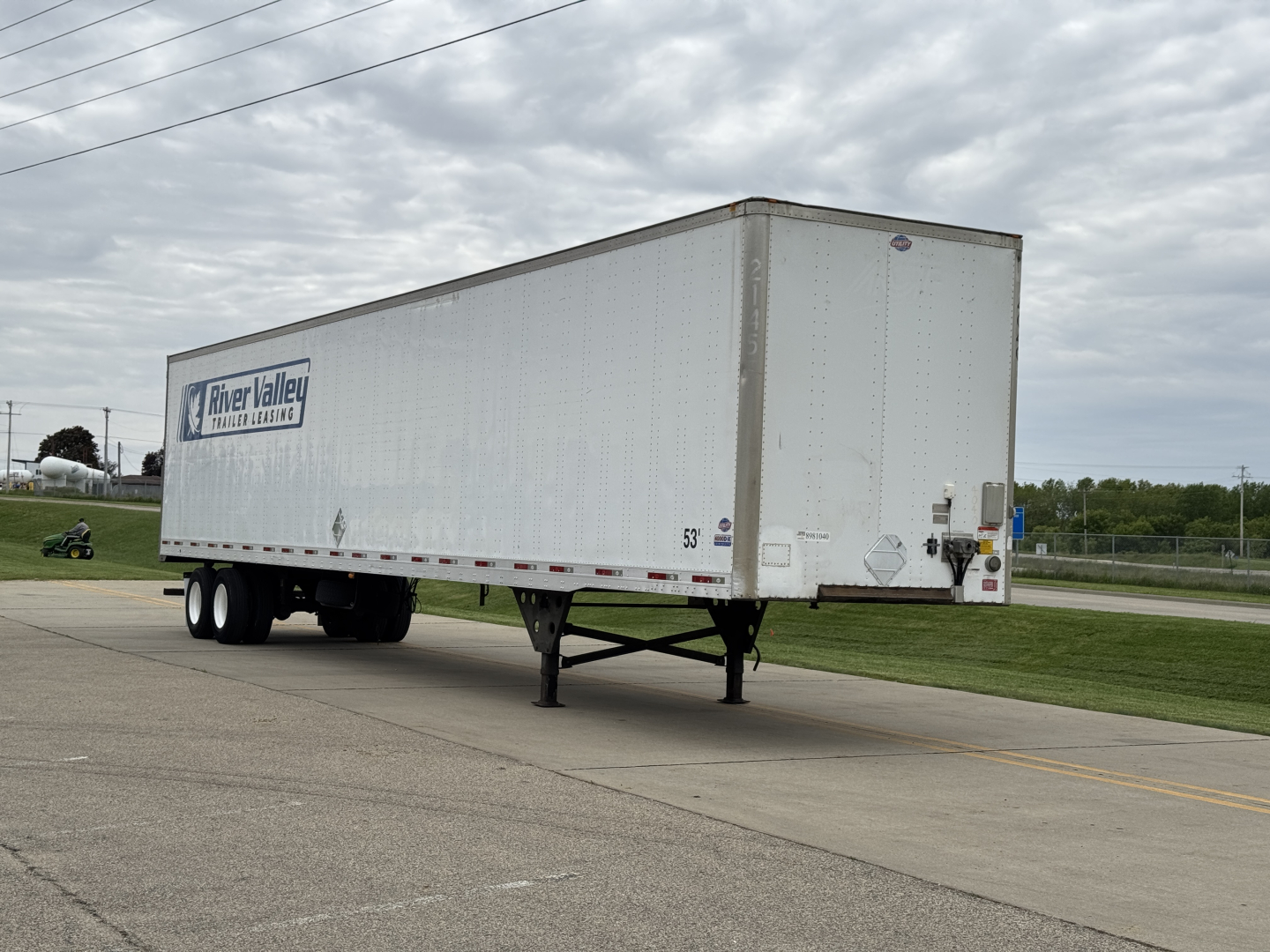 Trailer side view showing a white utility 4000D-X box trailer with a 'Meyer Valley' logo on the side, tandem axles, landing gear, and rear doors.