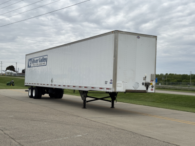 Trailer side view showing a white utility 4000D-X box trailer with a 'Meyer Valley' logo on the side, tandem axles, landing gear, and rear doors.