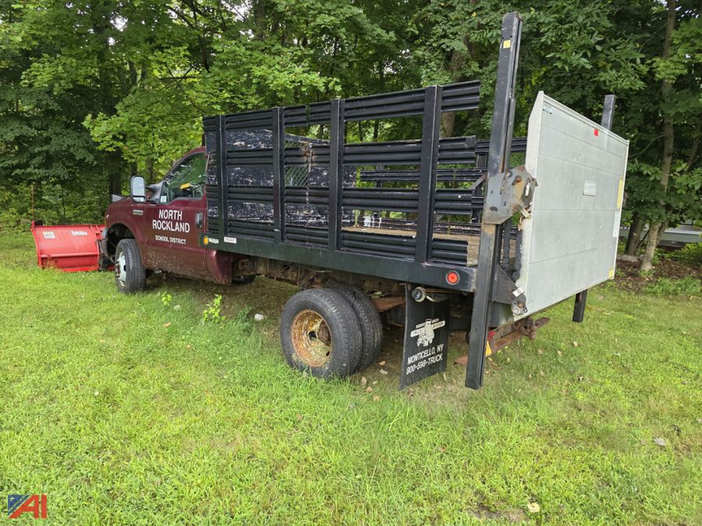 Ford F-350 Super Duty stake bed truck with a plow attachment and siderails, plumbed for a front winch, rear ramp, in-service condition.