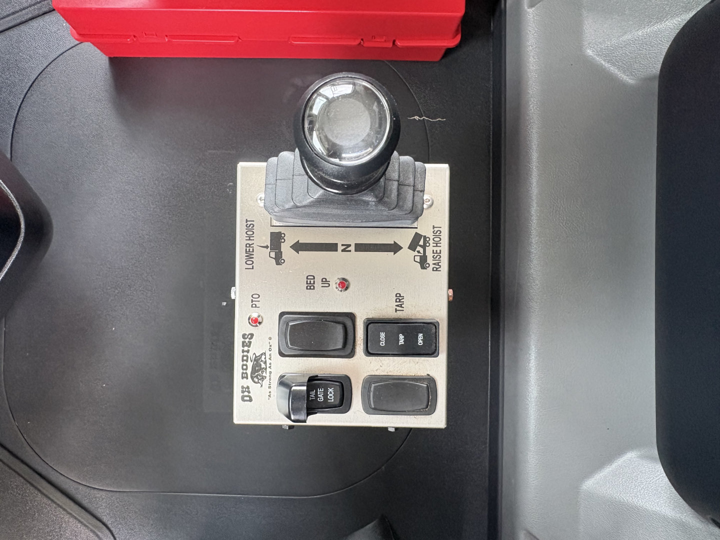 Mack GR64F dump truck control panel with joystick and switches; labels show various controls and indicators.