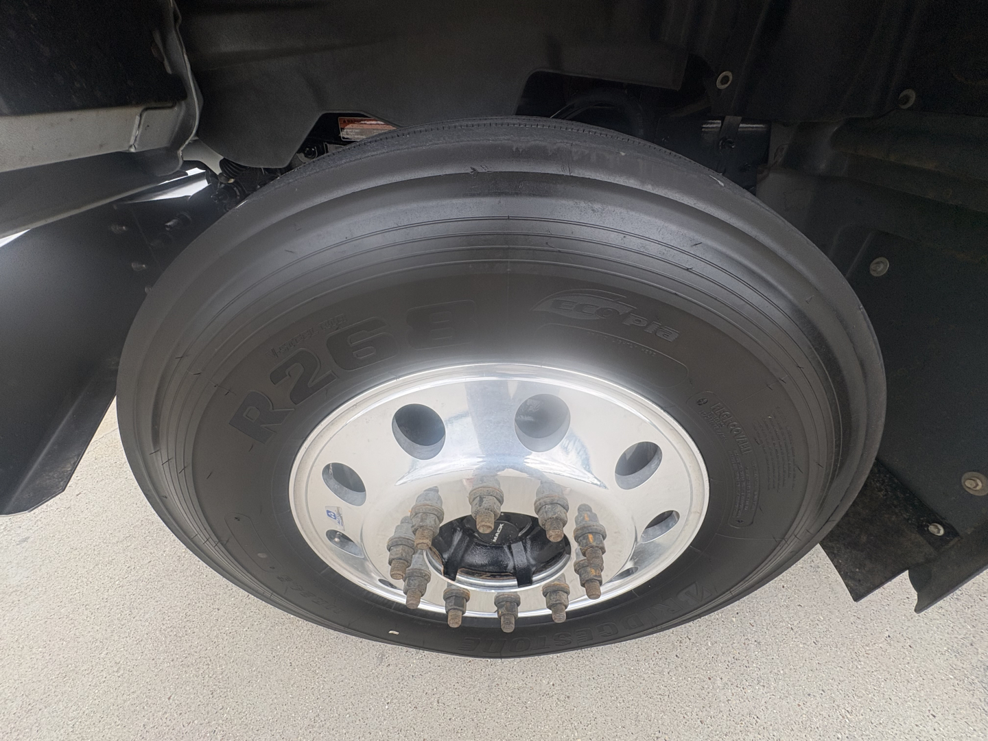 Mack GR64F truck wheel showing tire, aluminum rim, and lug nuts.