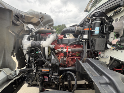 Mack GR64F engine bay showing primary engine components and hoses.