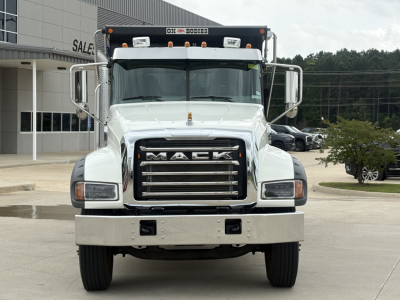 Mack GR64F dump truck front view showing Mack grille, bumper, headlights, and chrome mirrors.