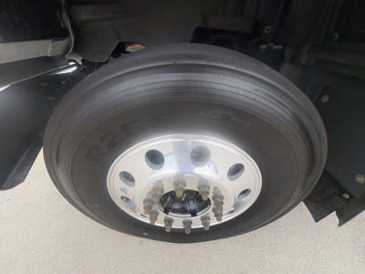 Mack GR64F truck wheel showing tire, aluminum rim, and lug nuts.