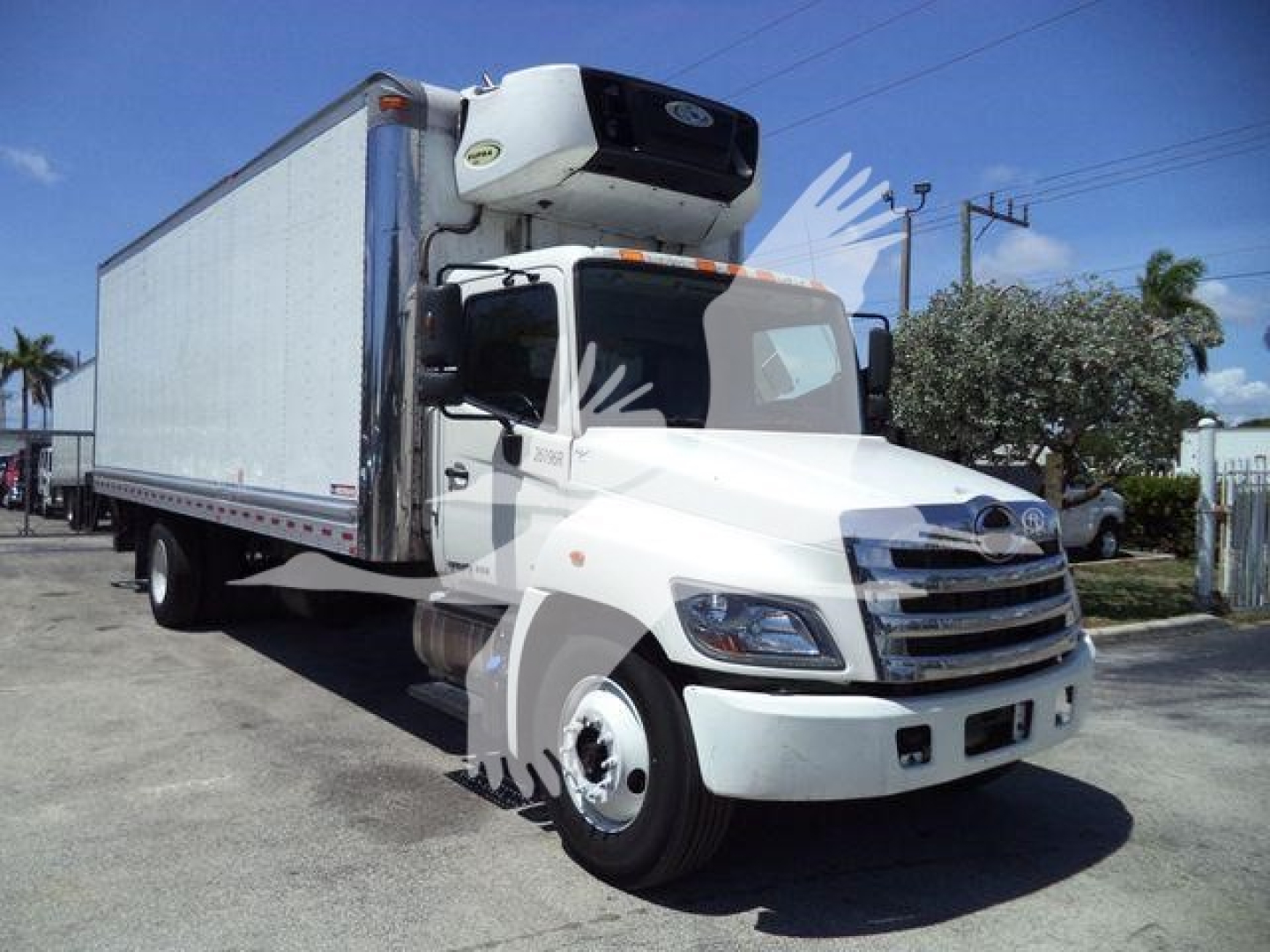Truck 2019 Hino 268A refrigerated box truck, front three-quarter view, white cab with black grille, cooling unit on top of box, stock number 26196RFM.