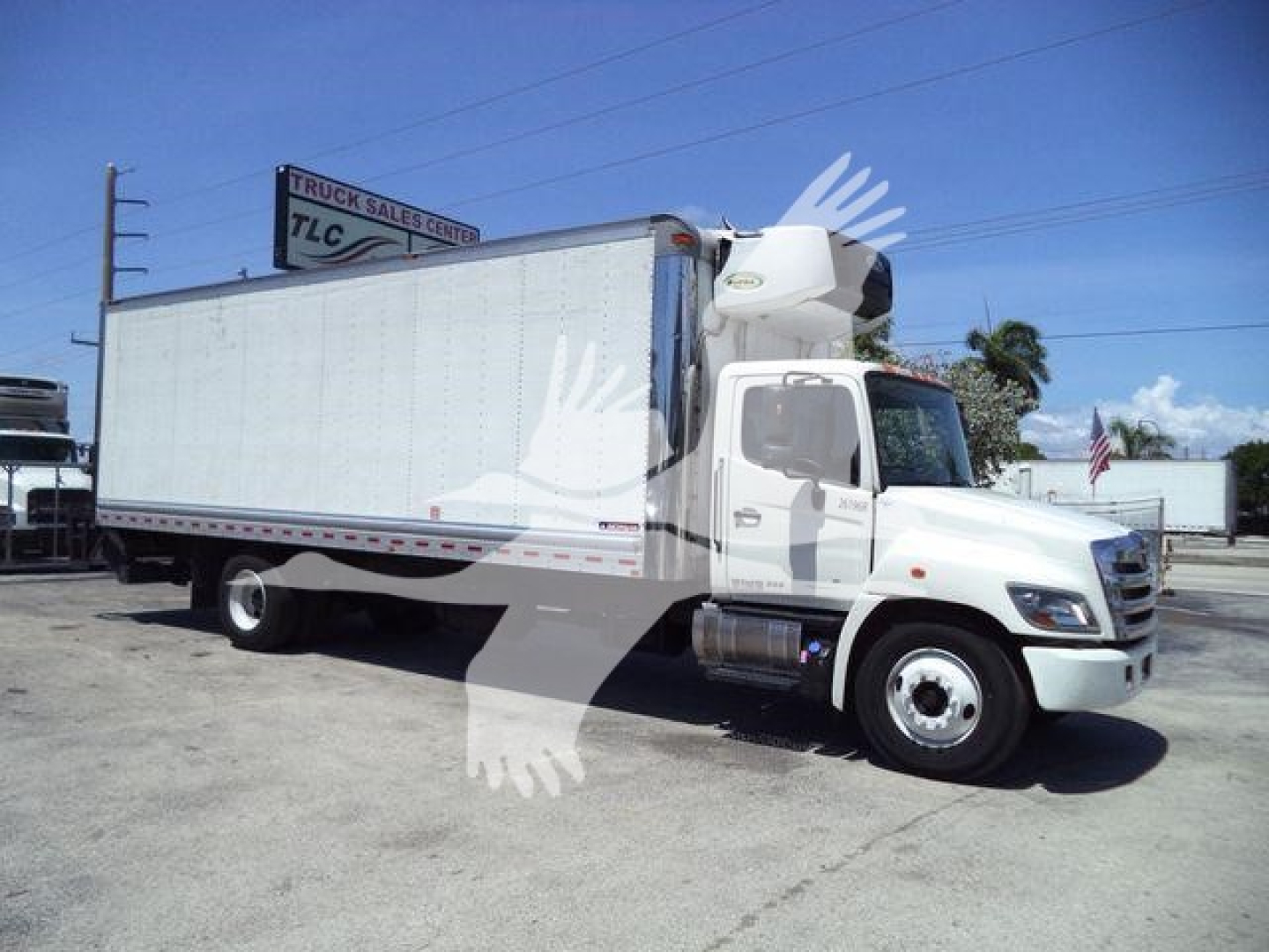 Truck side view: 2019 Hino 268A refrigerated box truck, white cab, large white cargo box, engine compartment, side mirrors, and refrigeration unit on top front of box.