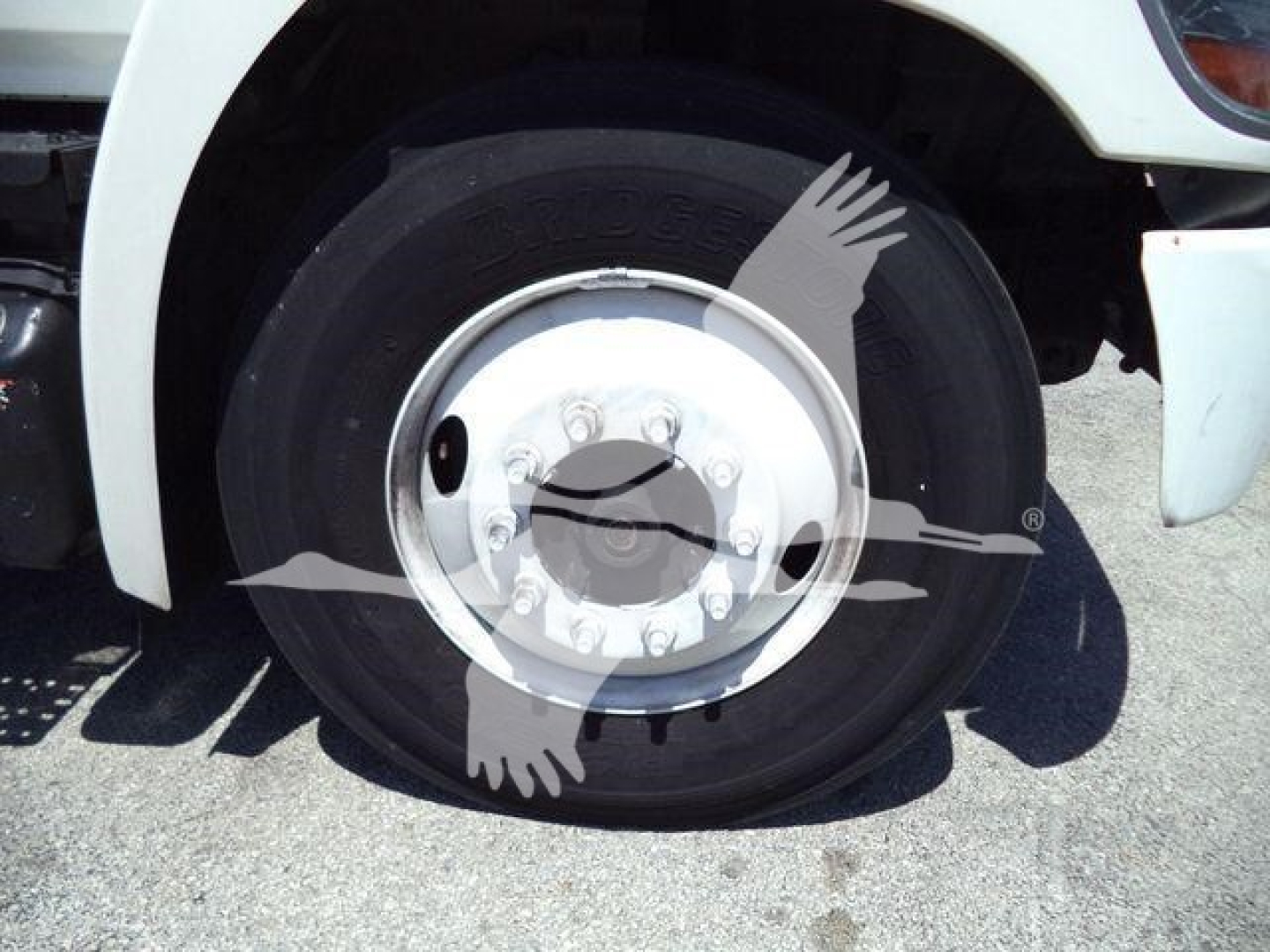 Wheel and hub of a 2019 Hino 268A refrigerated truck showing tire and chrome hubcap with lug nuts.