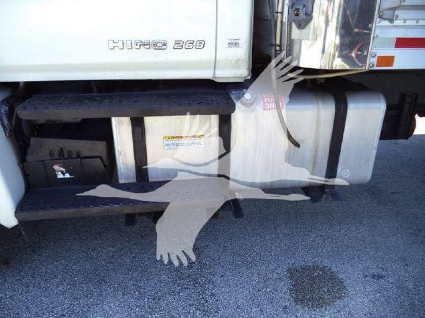 Hino 268 badge on the truck cab with side steps and fuel tank visible; faint 'HINO 268' text on door panel.