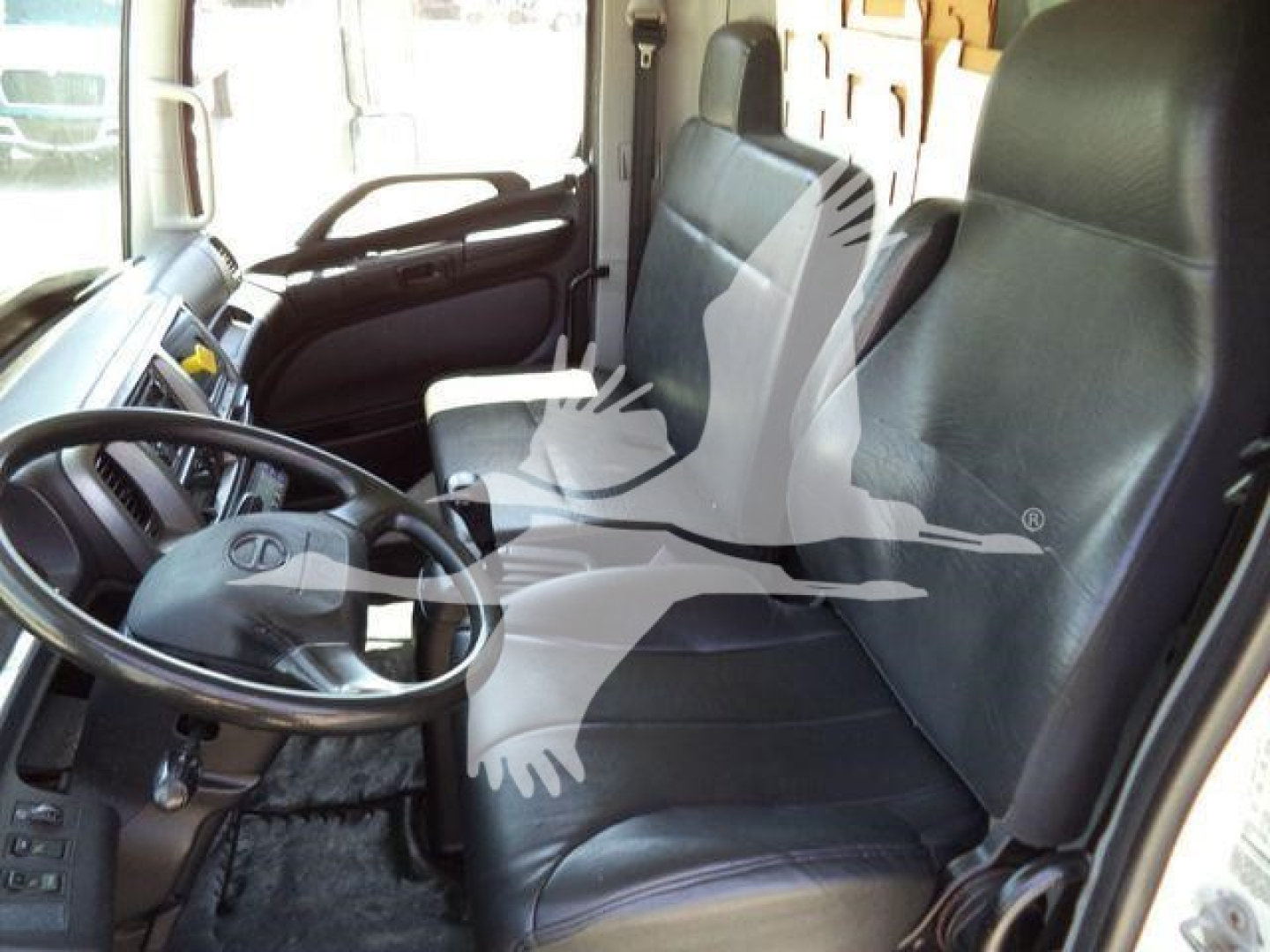 Cab interior of a 2019 Hino 268A refrigerated truck showing steering wheel, driver's seat, and dashboard.