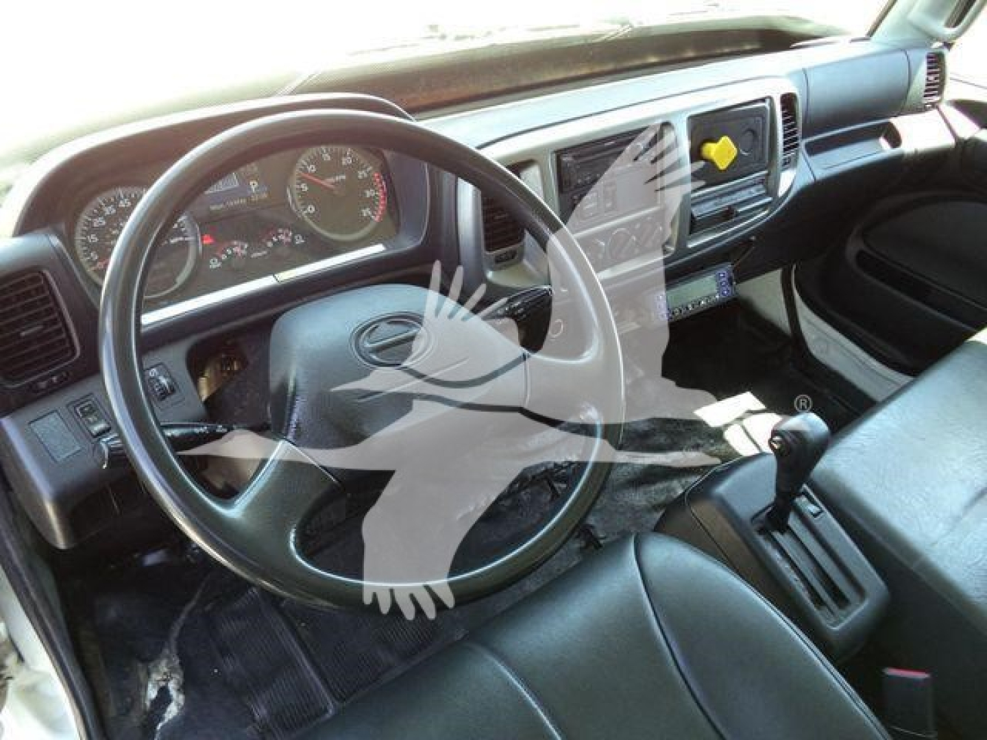 Truck cab interior of 2019 Hino 268A showing steering wheel, dashboard, and gear shift.