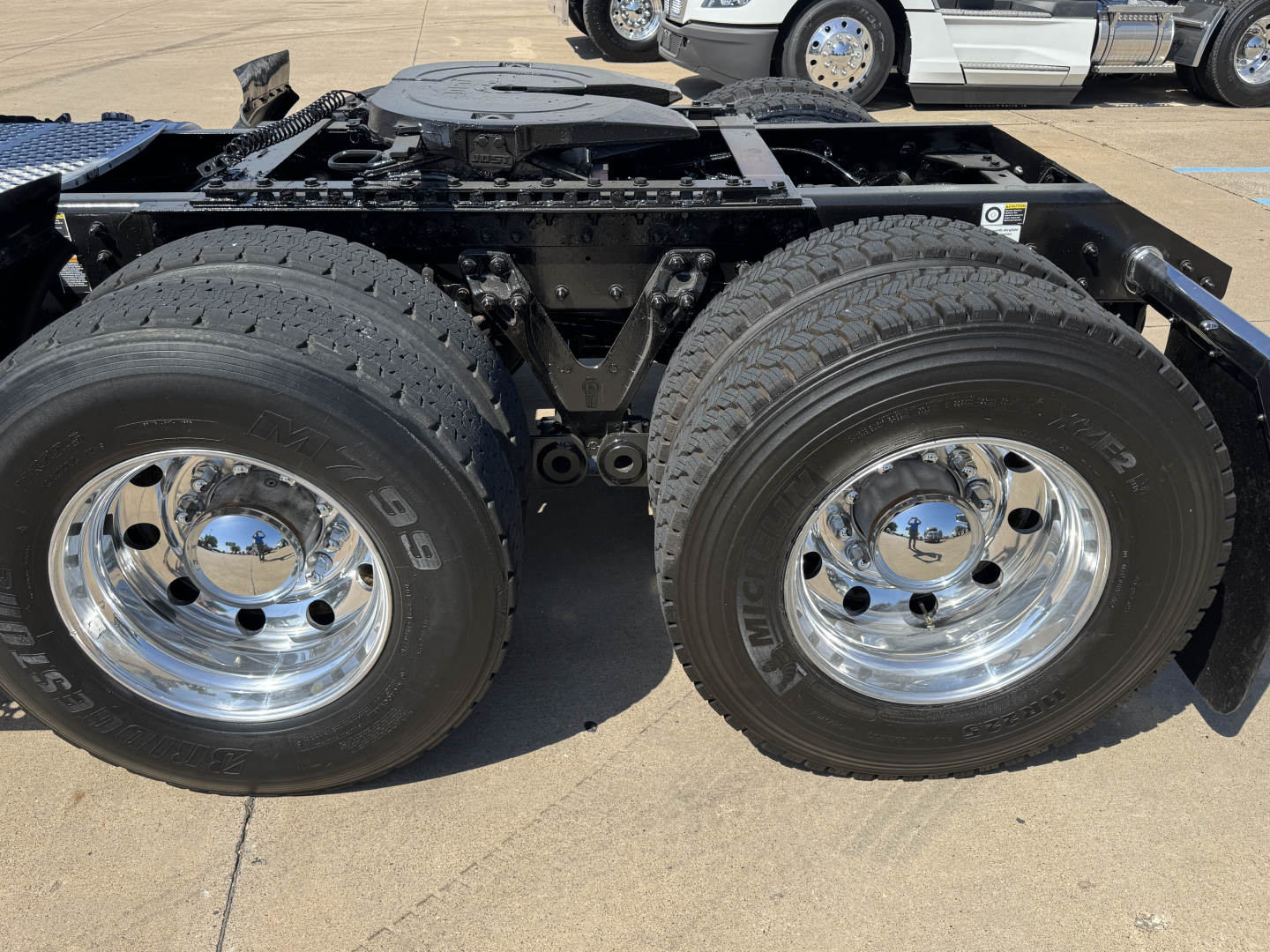 Kenworth T680 chassis and dual rear wheels showing heavy-duty tires and chrome wheels, fuel/air lines and frame rails visible.
