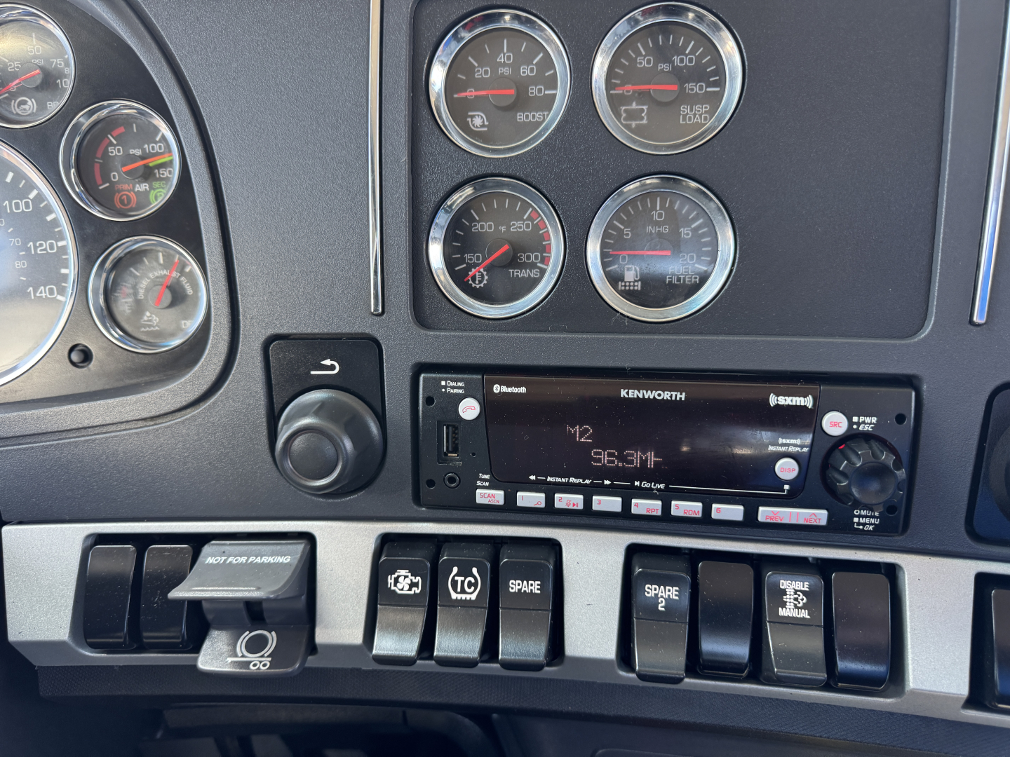 Kenworth T680 dashboard and radio showing gauges and switches; radio display 96.3M and various control buttons visible.