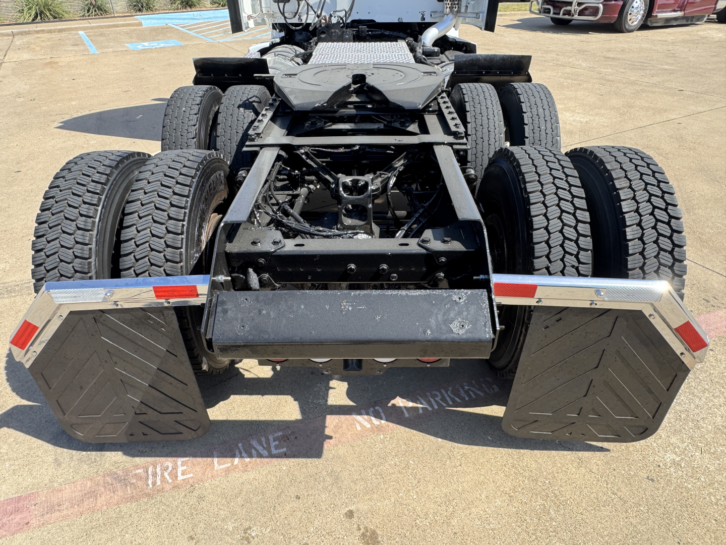 Kenworth T680 rear chassis showing dual rear axles with mud flaps and frame rails, stock number 0629089 visible, overhead fuel tanks and fifth wheel area.