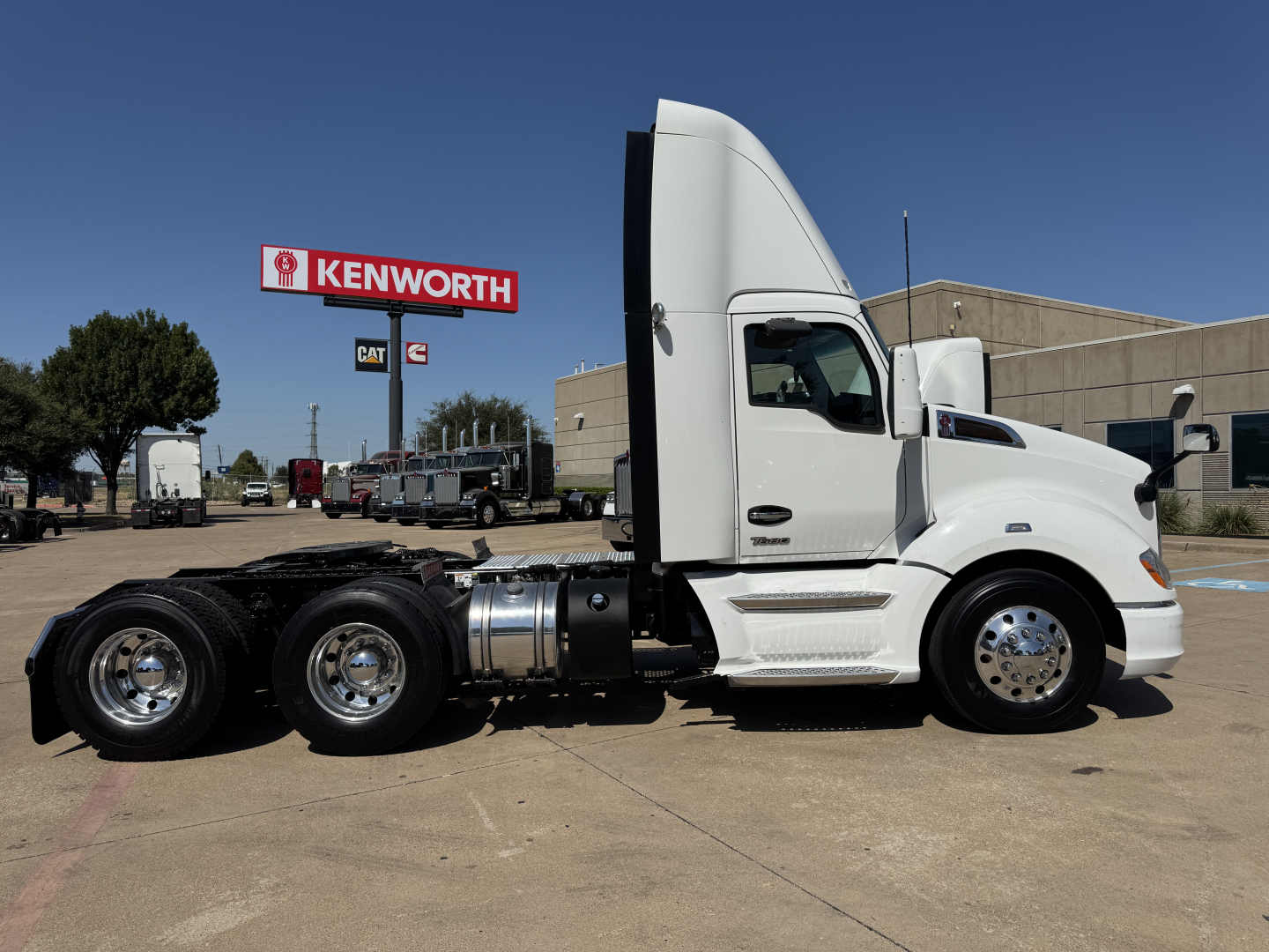 Kenworth T680 semi-truck side profile showing cab, fuel tanks, and rear dual-axle chassis in a parking lot.