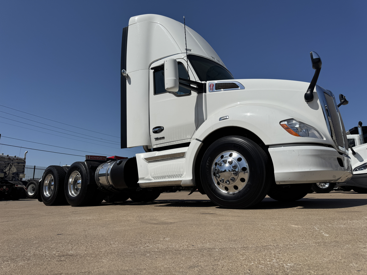 Kenworth T680 conventional daycab truck side view showing cab, front fender, chrome wheels, fuel tanks, and dual rear axles.
