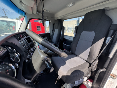 Kenworth T680 truck cab interior showing steering wheel, instrument cluster, driver seat, and passenger seat; dashboard with gauges and controls.