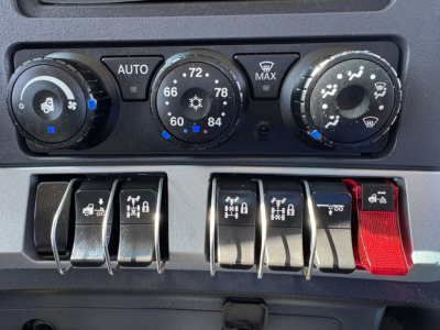 Kenworth T680 dash climate controls and switch panel showing rotary dials and multiple switches.