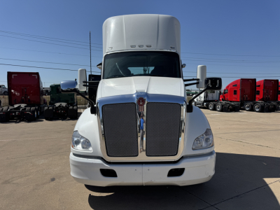 Kenworth T680 daytime cab front view showing large chrome grille, white exterior, and dual side mirrors.