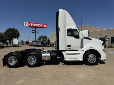 Kenworth T680 semi-truck side profile showing cab, fuel tanks, and rear dual-axle chassis in a parking lot.