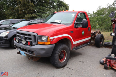 1999 Ford F-350 Super Duty cab and chassis truck in red with white stripe, front view, auxiliary lights on bumper, off-road tires.