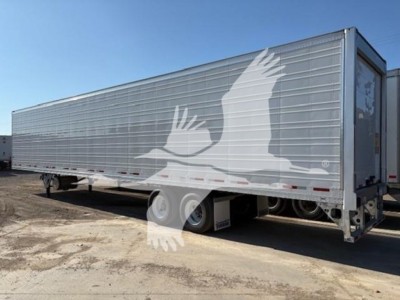  trailer showing side and rear of a Vanguard R8000B refrigerated trailer with logo on side, aluminum panels, triple axles, and rear doors.