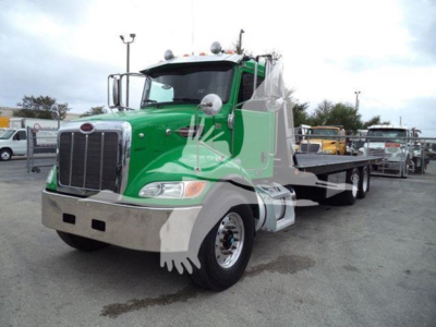 Peterbilt 348 rollback truck in green and silver with chrome bumper and dual rear axles, front grille and cab mirrors visible.