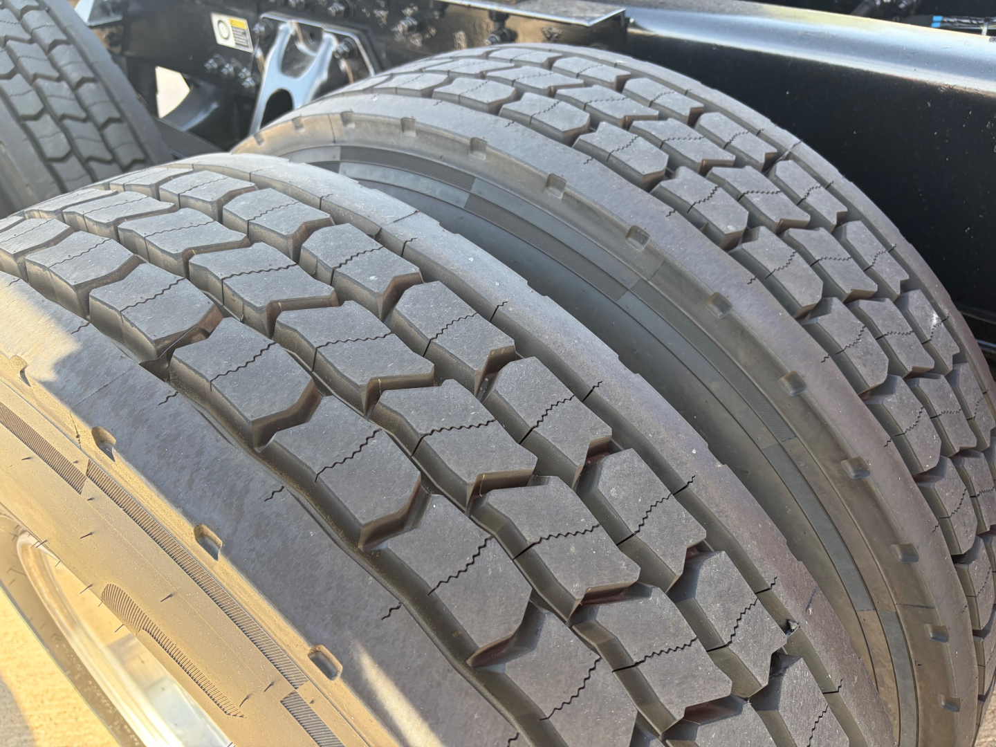 Kenworth T680 wheel and dual rear tires showing tread pattern and sidewall details.