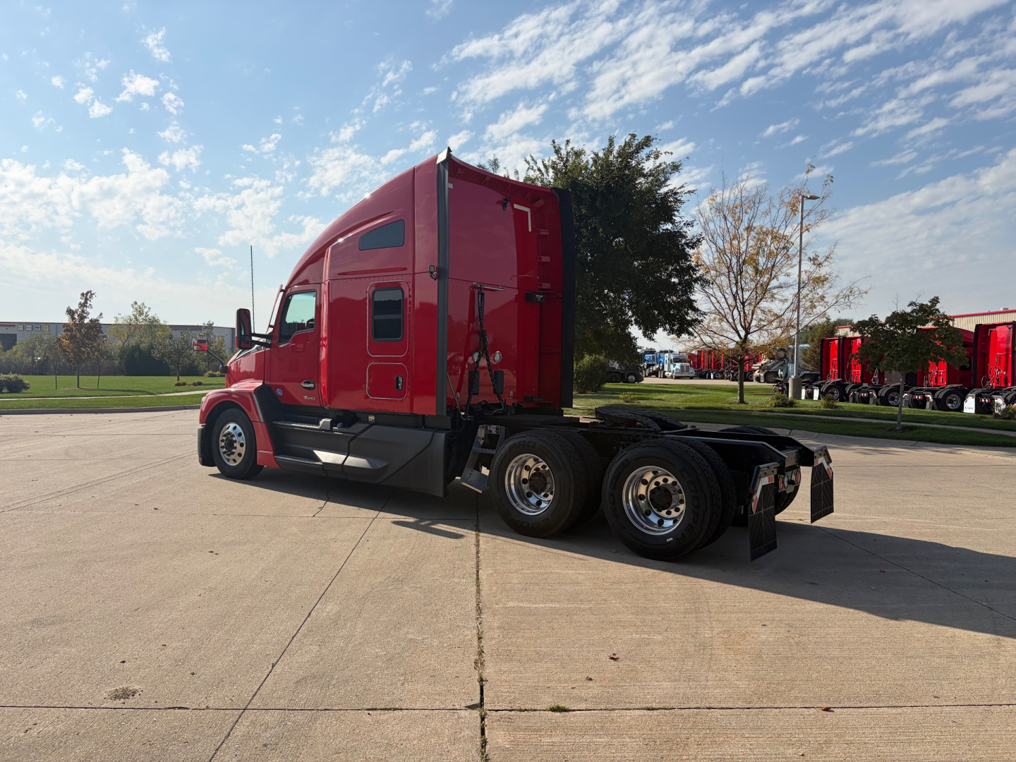 Kenworth T680 tractor in red color, side view showing sleeper cab, dual rear axles, and chrome wheels; no visible text on the truck exterior (no legible labels clearly present).