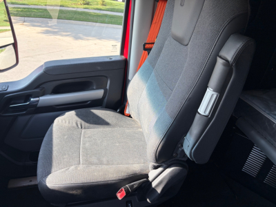 Vehicle cab interior of a 2024 Kenworth T680 truck showing front seat and seat belt. No engine or labels visible.
