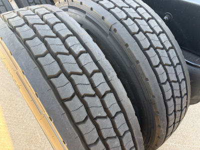 Dual rear tires of a Kenworth truck wheel assembly in view showing tread and outer rim.