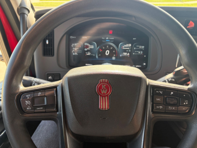 Kenworth T680 steering wheel and instrument cluster with digital gauges in view.