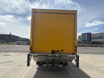 Truck rear view with a yellow box cargo area and underride guard.
