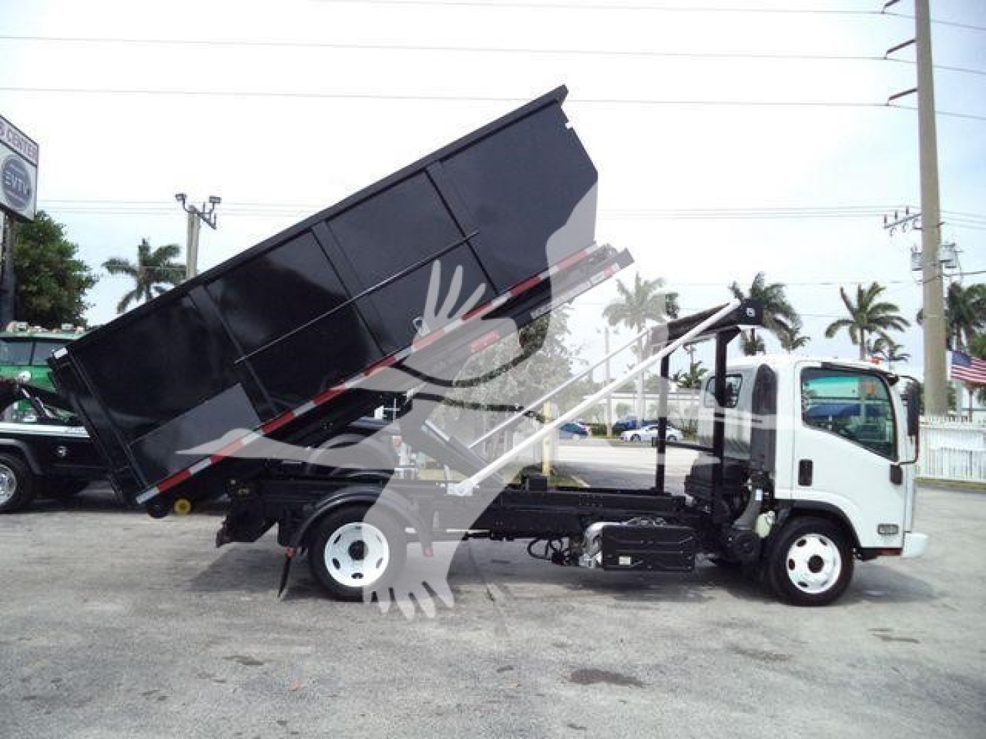Isuzu NPR/NRR roll-off truck with dump bed raised, side view showing cab and chassis with white wheels.