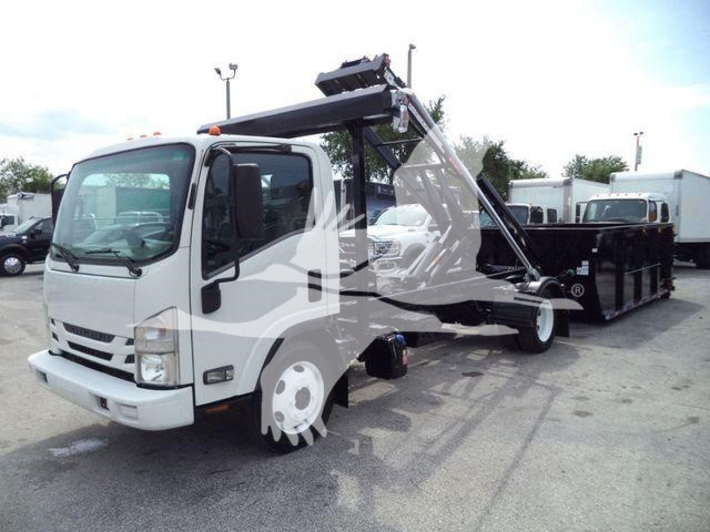 Isuzu NPR roll-off truck with front cab and hooklift hoist in view showing crane and dump bed.