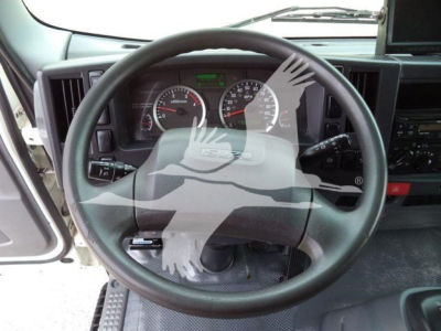 Isuzu NRR cabin interior with steering wheel and instrument cluster; dashboard displays analog gauges and a green display; no other text legible.