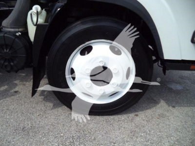 Front wheel and tire of a 2017 Isuzu NPRR roll-off truck showing wheel, hubcap, and part of front fender.