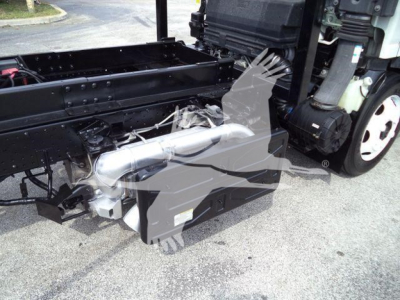 Isuzu NPR/NRR truck chassis showing a hydraulic system component and frame; side view with white cab wheel visible.