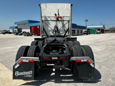 Truck chassis rear view showing dual rear axles and mud flaps with Bruckner's Truck Equipment logo, fifth wheel and wiring harness visible in a used 2020 Mack Anthem.