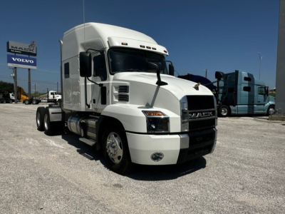 Mack Anthem tractor in white shown in a dealership lot with other trucks in background