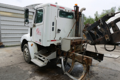 Truck cab rear view showing Freightliner CL112 daycab with attached hydraulic arm and frame, white exterior with decals and stock number 0607248.