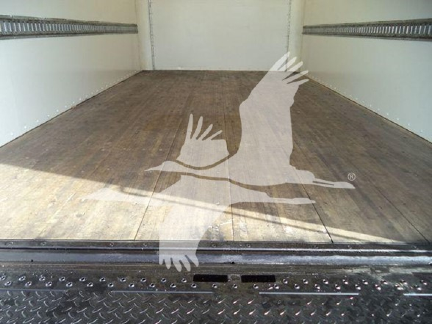 Isuzu NPR HD truck cargo area with wooden floor, empty box, interior side walls visible.