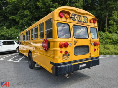 Yellow 2016 Blue Bird Vision school bus rear view showing taillights, back doors, and school bus signage.