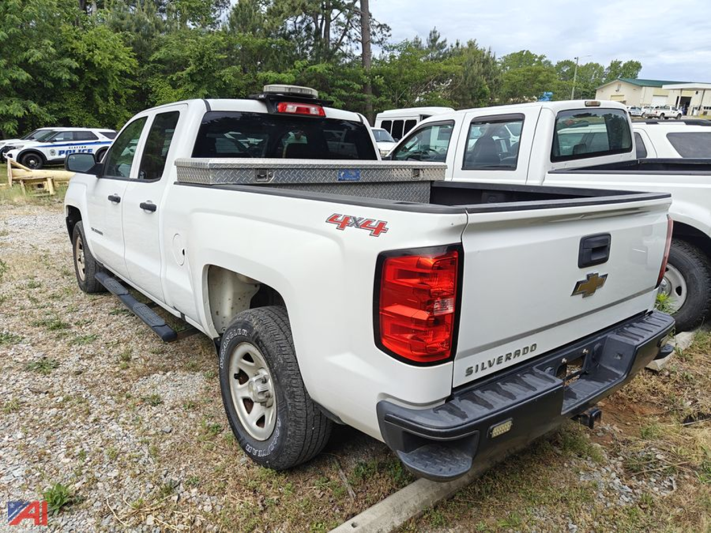 Truck bed of white 2017 Chevrolet Silverado 1500 crew cab 4x4 showing rear and tailgate badge text Silverado and Chevrolet bowtie, with tonneau cover and step bumper.