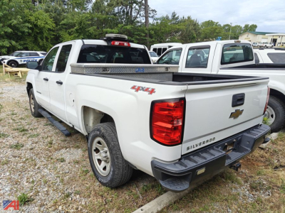 Truck bed of white 2017 Chevrolet Silverado 1500 crew cab 4x4 showing rear and tailgate badge text Silverado and Chevrolet bowtie, with tonneau cover and step bumper.