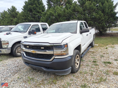 White 2017 Chevrolet Silverado 1500 Crew Cab pickup truck front-left view in a gravel lot with other vehicles and trees in background.