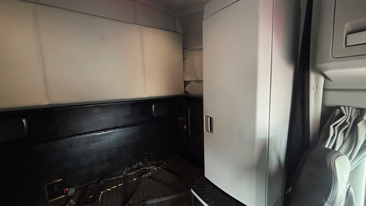 Kenworth T680 truck cab interior showing sleeper area with cabinetry and storage.