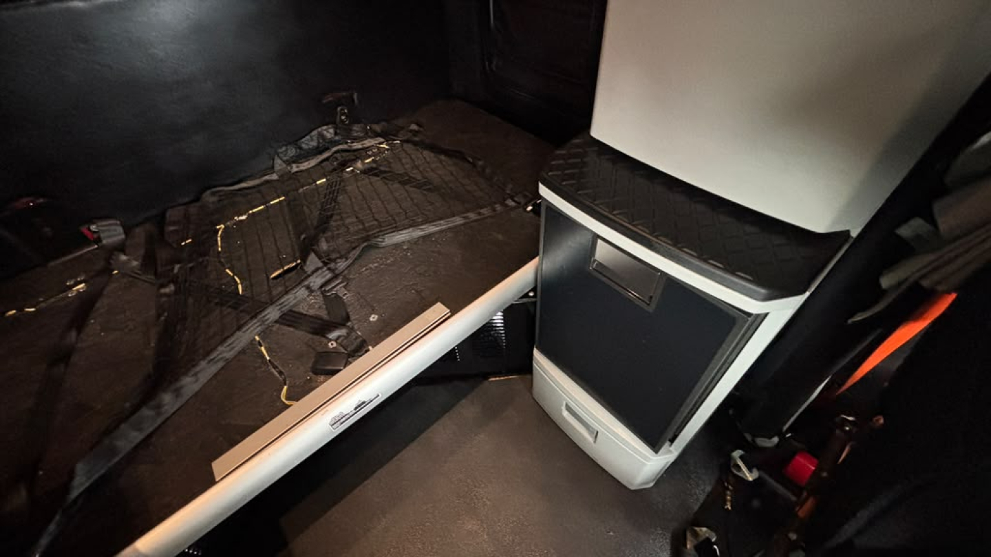 Kenworth T680 interior showing center console and floor area with cables and trim pieces.