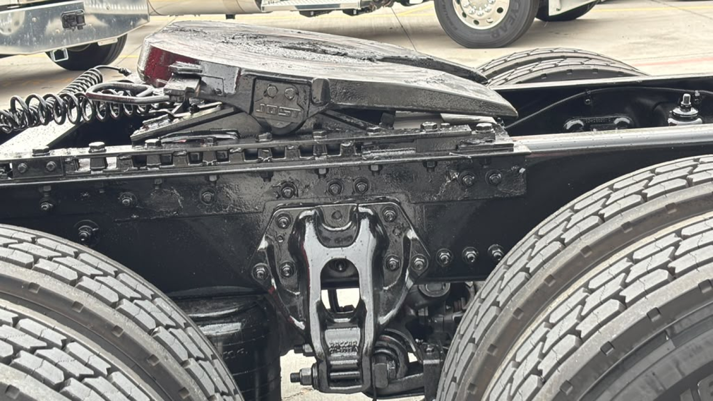 Six-wheel tractor rear view showing fifth-wheel/landing gear area and dual rear tires in a Kenworth T680 truck chassis.