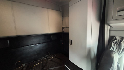 Kenworth T680 truck cab interior showing sleeper area with cabinetry and storage.